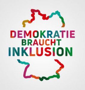 Das Logo des Beauftragten der Bundesregierung für die Belange von Menschen mit Behinderungen: eine schematische Darstellung der BRD. Die Umrisse des Landes sind in verschiedenen Farben gestaltet. In der Mitte steht in bunten Großbuchstaben: “Demokratie braucht Inklusion“